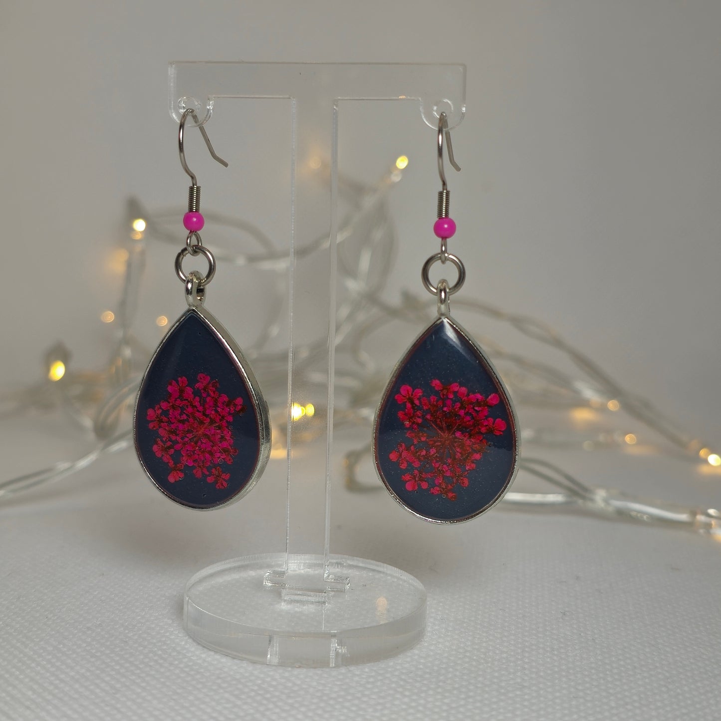 Earrings - Acrylic resin, bright pink flowers on a bed of deep navy blue resin