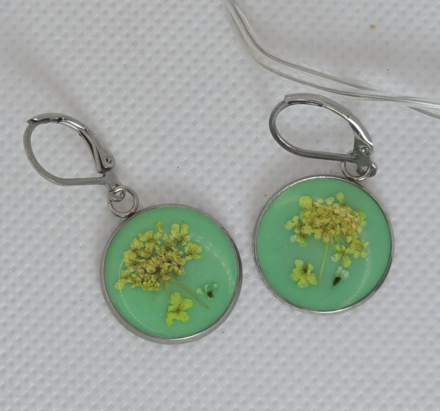 Earrings - Acrylic resin dangle earrings with tiny yellow flowers laid on a light green resin base