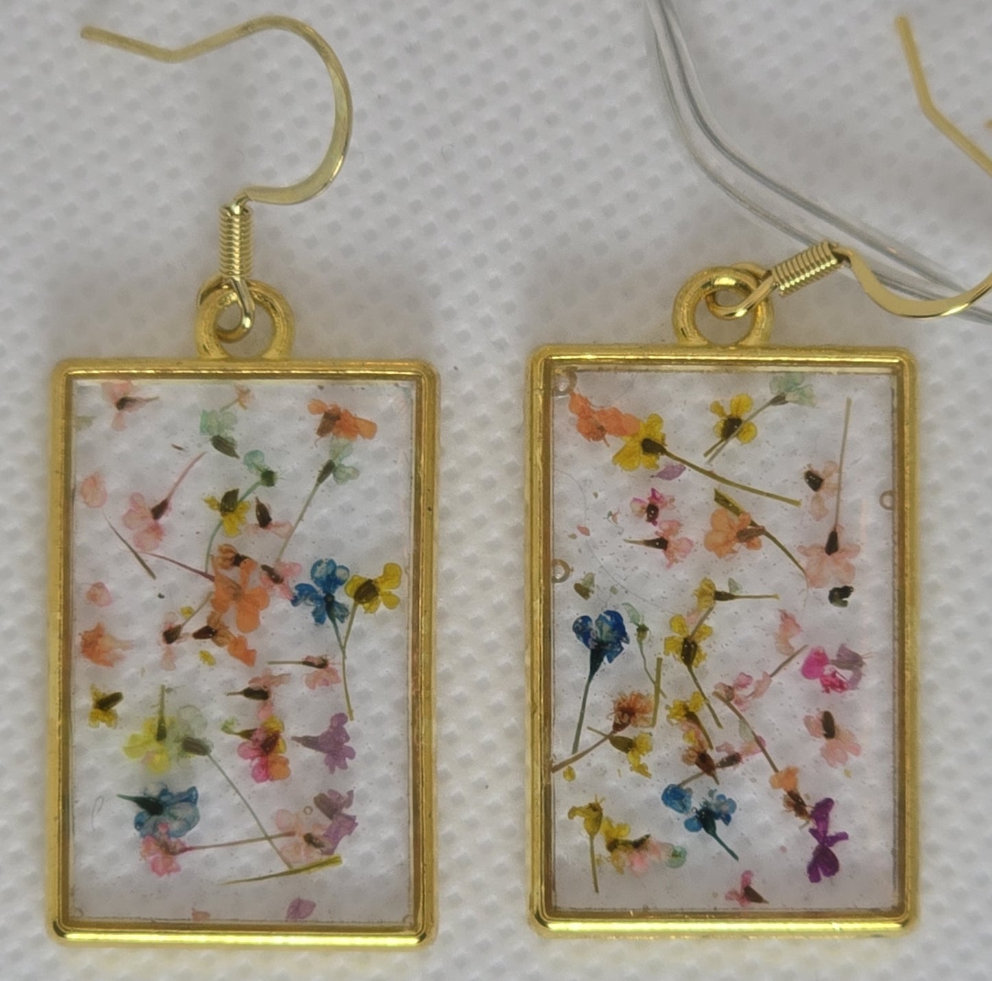 Earrings - Acrylic resin, tiny multi colour flowers encased in clear resin framed in a rectangular gold frame