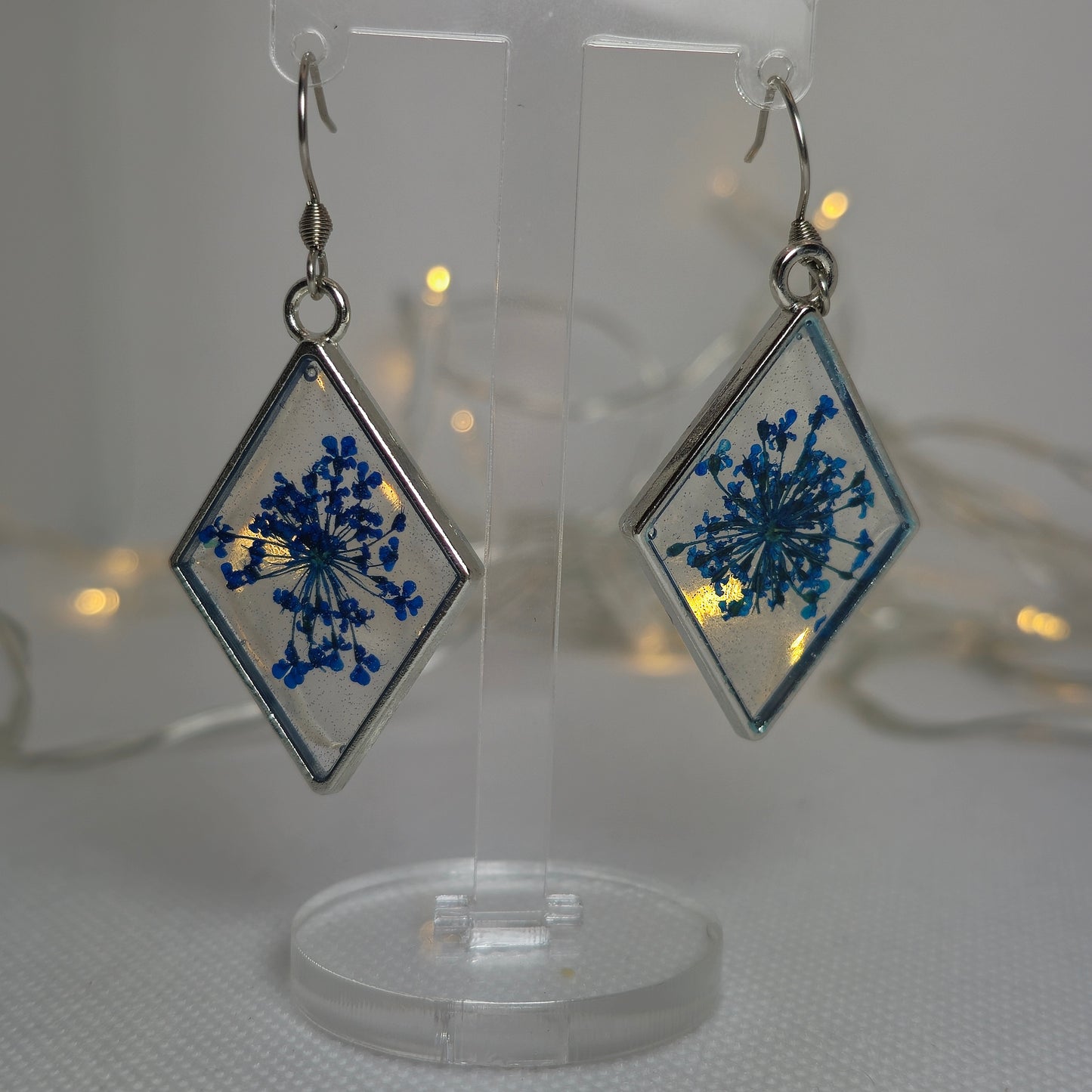 Earrings - Acrylic resin, clear base with small blue flowers, diamond-shaped silver-look bezel, blue