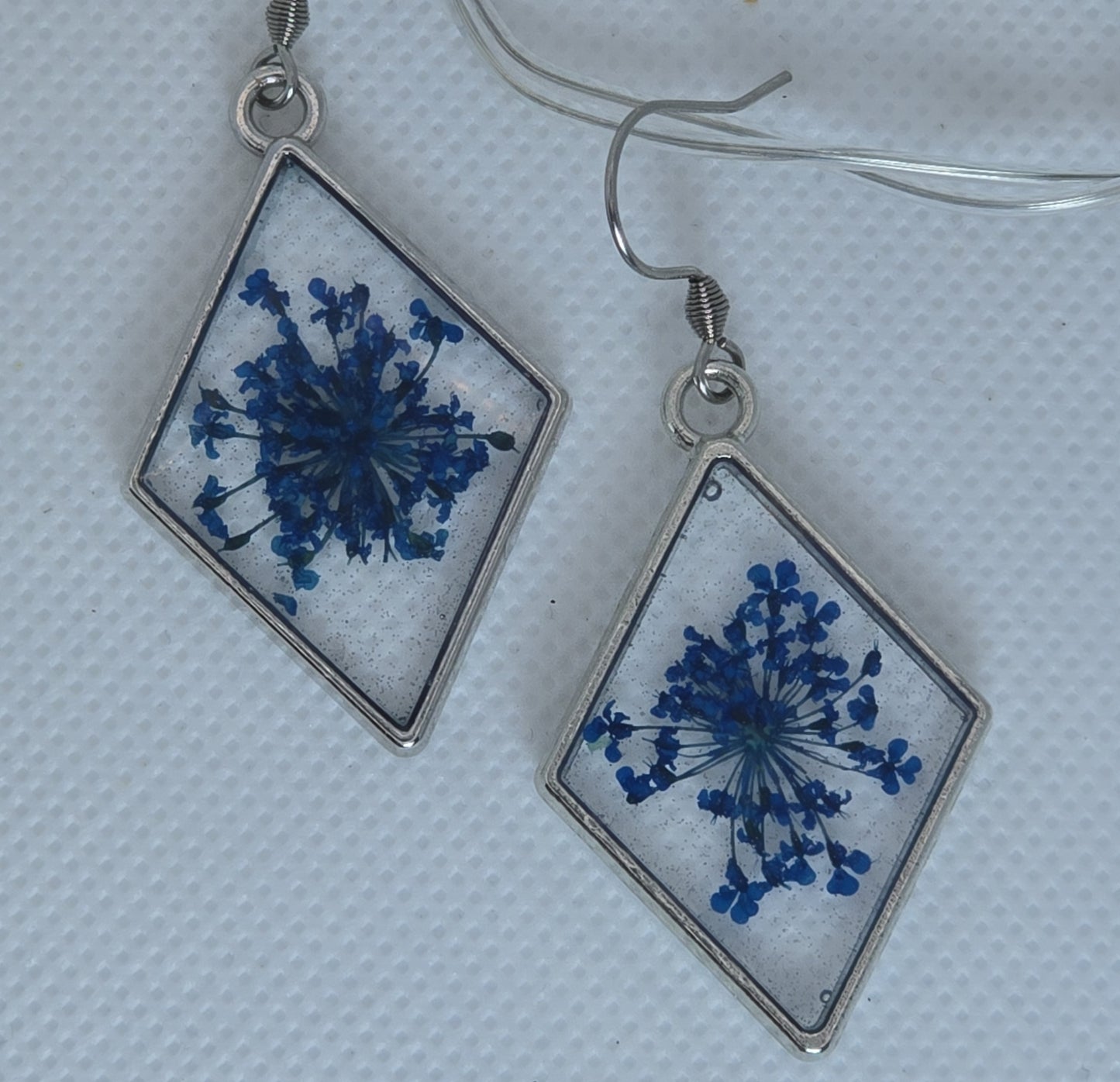 Earrings - Acrylic resin, clear base with small blue flowers, diamond-shaped silver-look bezel, blue