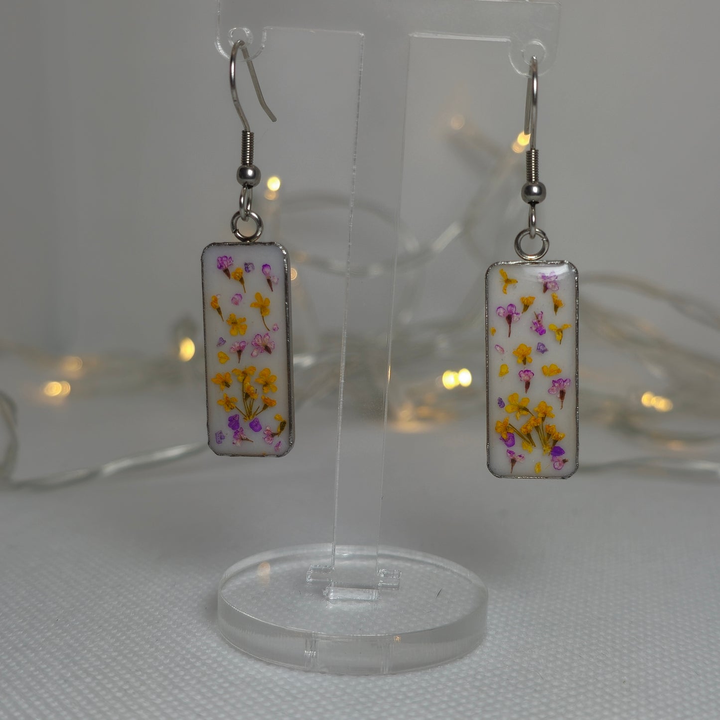 Earrings - resin-filled rectangular tray filled a sprinkling of delicate Queen Anne's lace flowers in orange and purple, on a bed of white