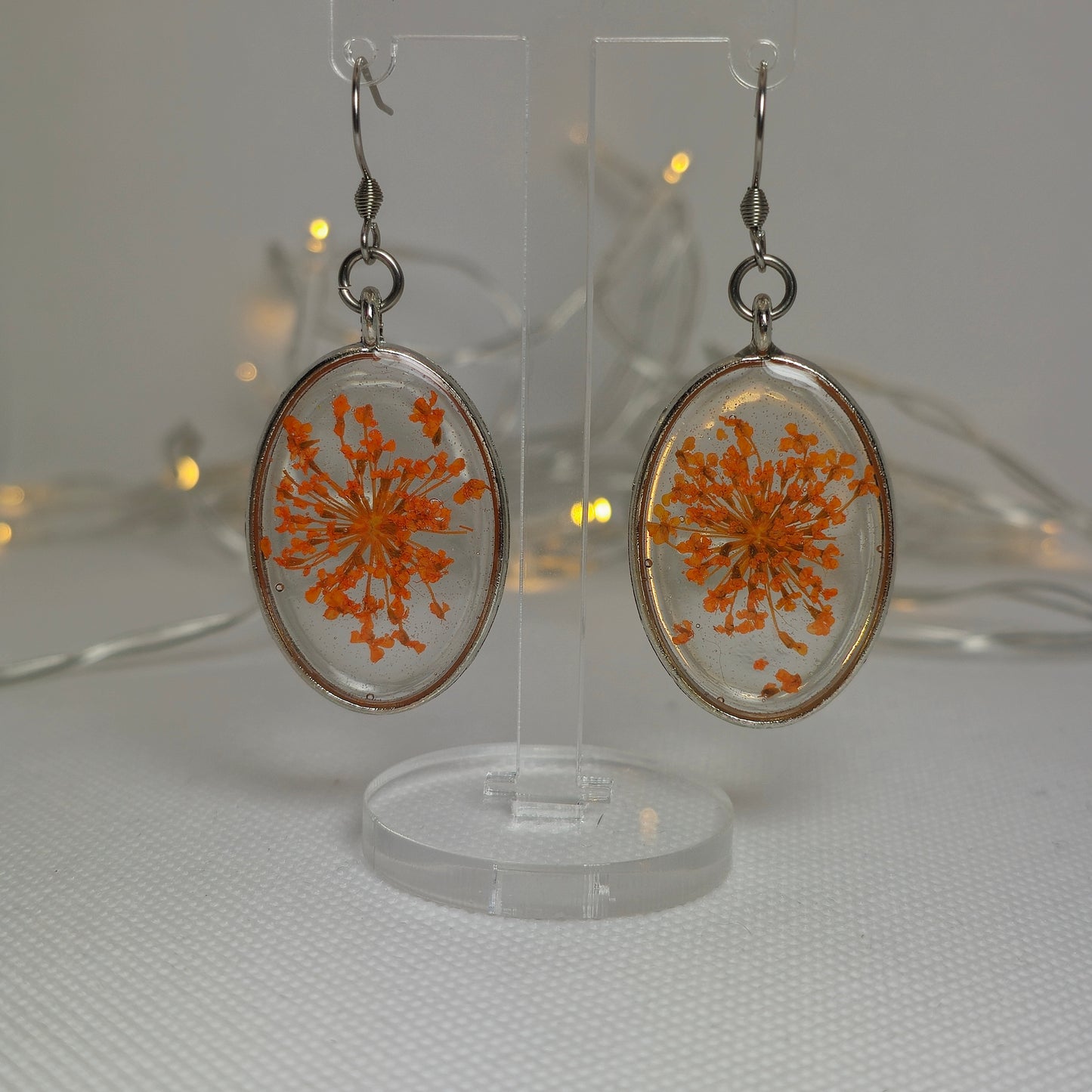 Earrings: Oval shaped bezel with orange Queen Anne's Lace floating in clear resin