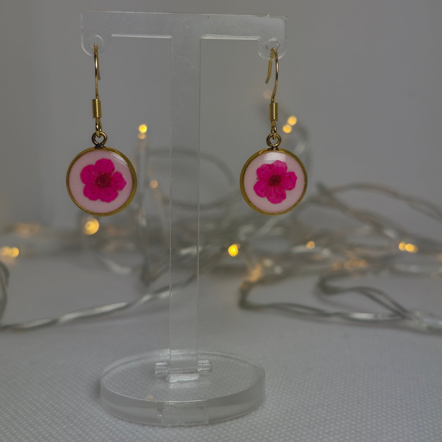Earrings, Single cerise pink Alyssum flowers resting on beds of pale pink acrylic resin, contained in a dainty round gold-coloured bezel.