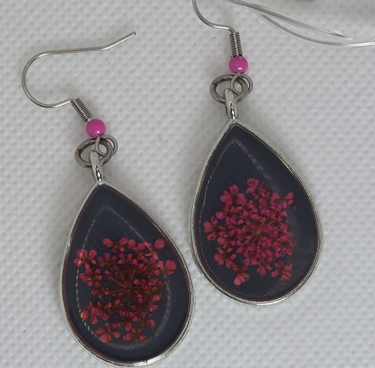 Earrings - Acrylic resin, bright pink flowers on a bed of deep navy blue resin