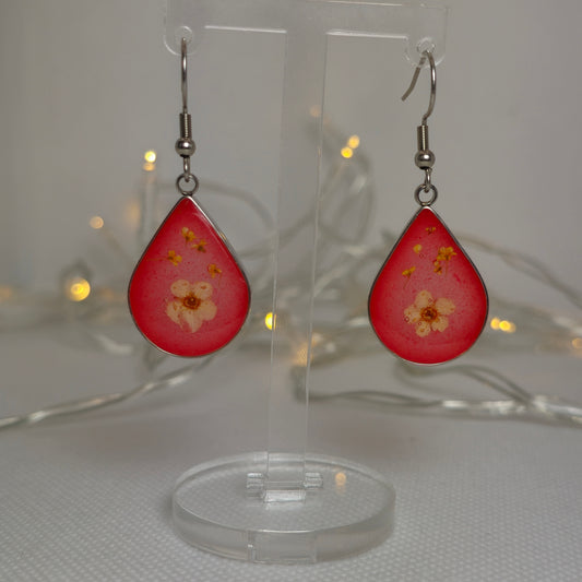 Earrings: silver-look teardrop shaped earrings with a white Alyssum flower and tiny Queen Anne's Lace, floating in translucent red acrylic resin